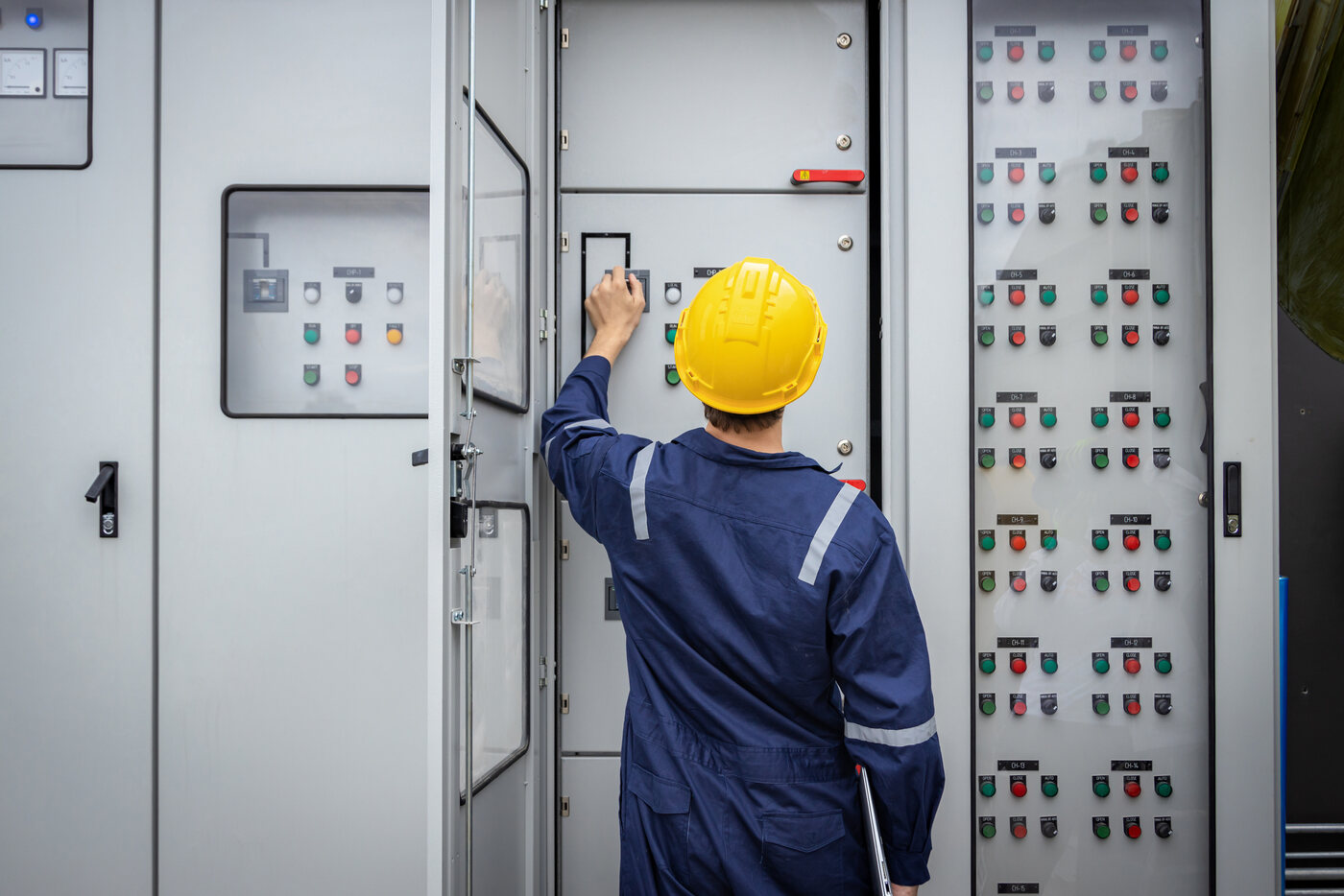 Engineer inspecting an industrial electrical control panel